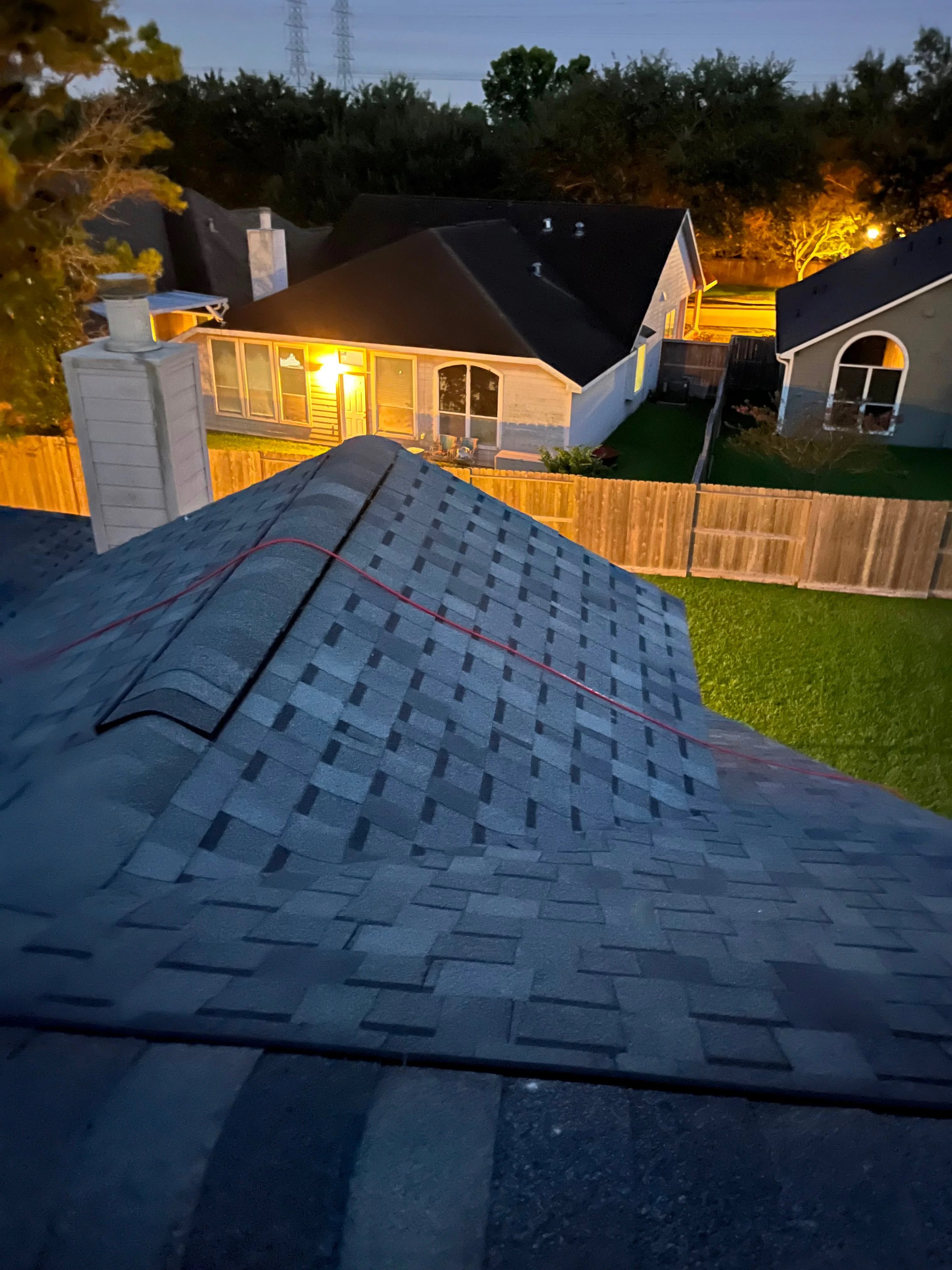 Slate gray architectural shingles installed on residential roof with ridge vents and flashing