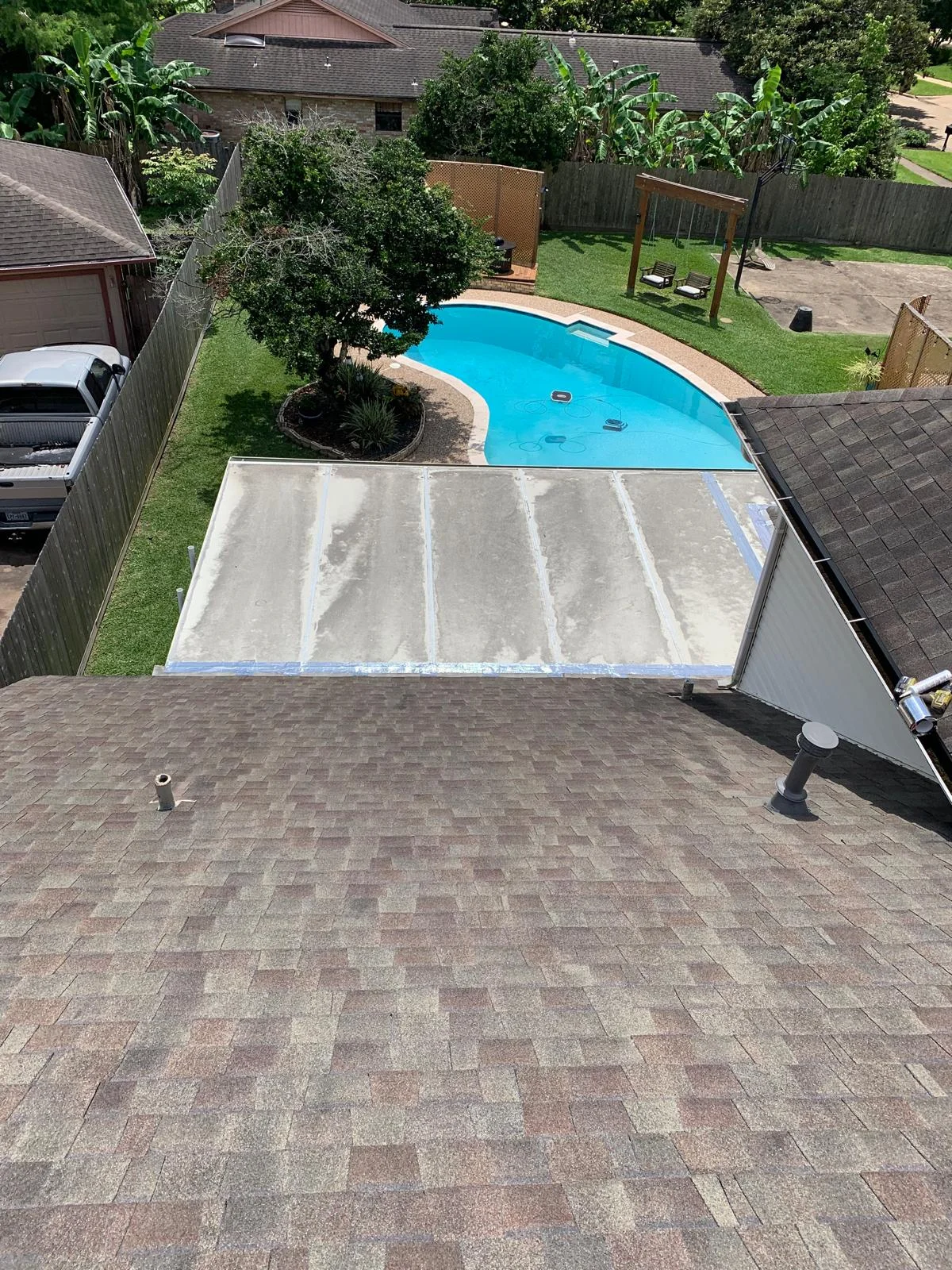 Newly installed architectural shingles in gray and brown blend on residential roof