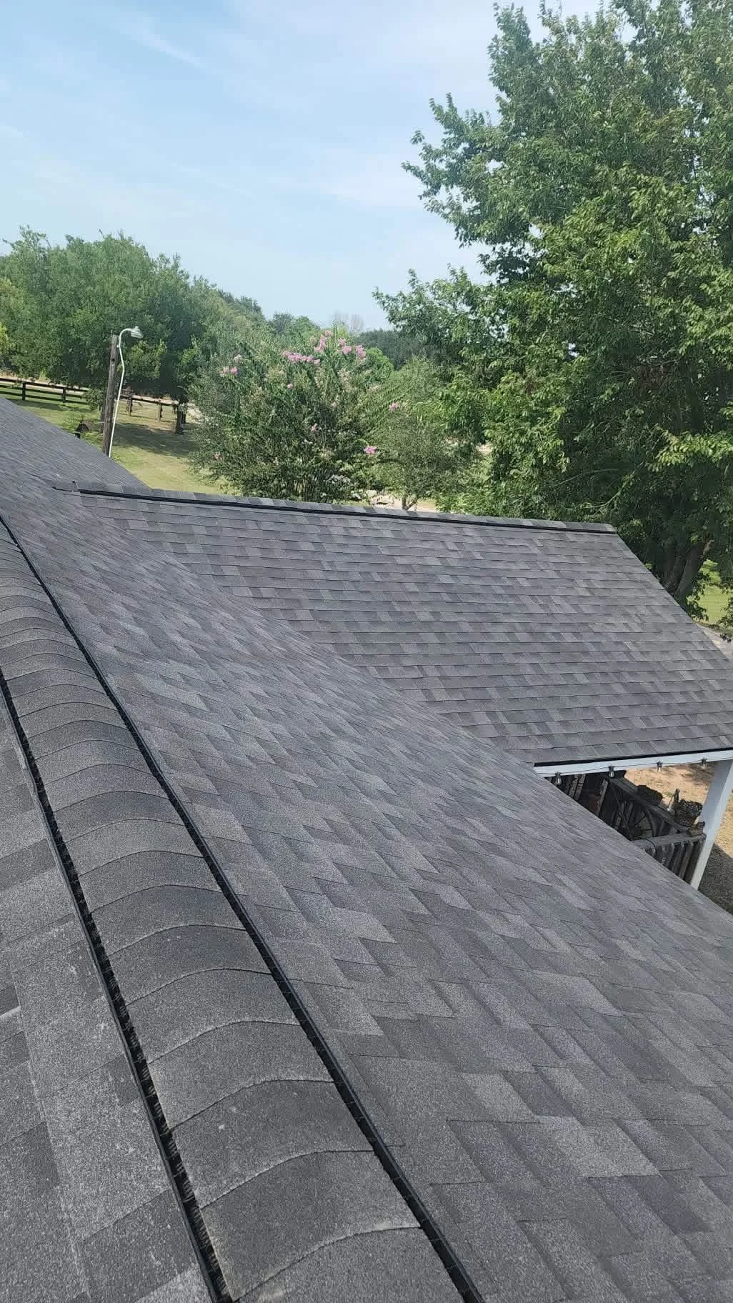 Charcoal gray architectural shingles installed on residential roof with proper flashing and clean seams