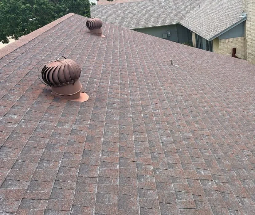 Brown architectural shingles with ridge vent and turbine vents on pitched roof