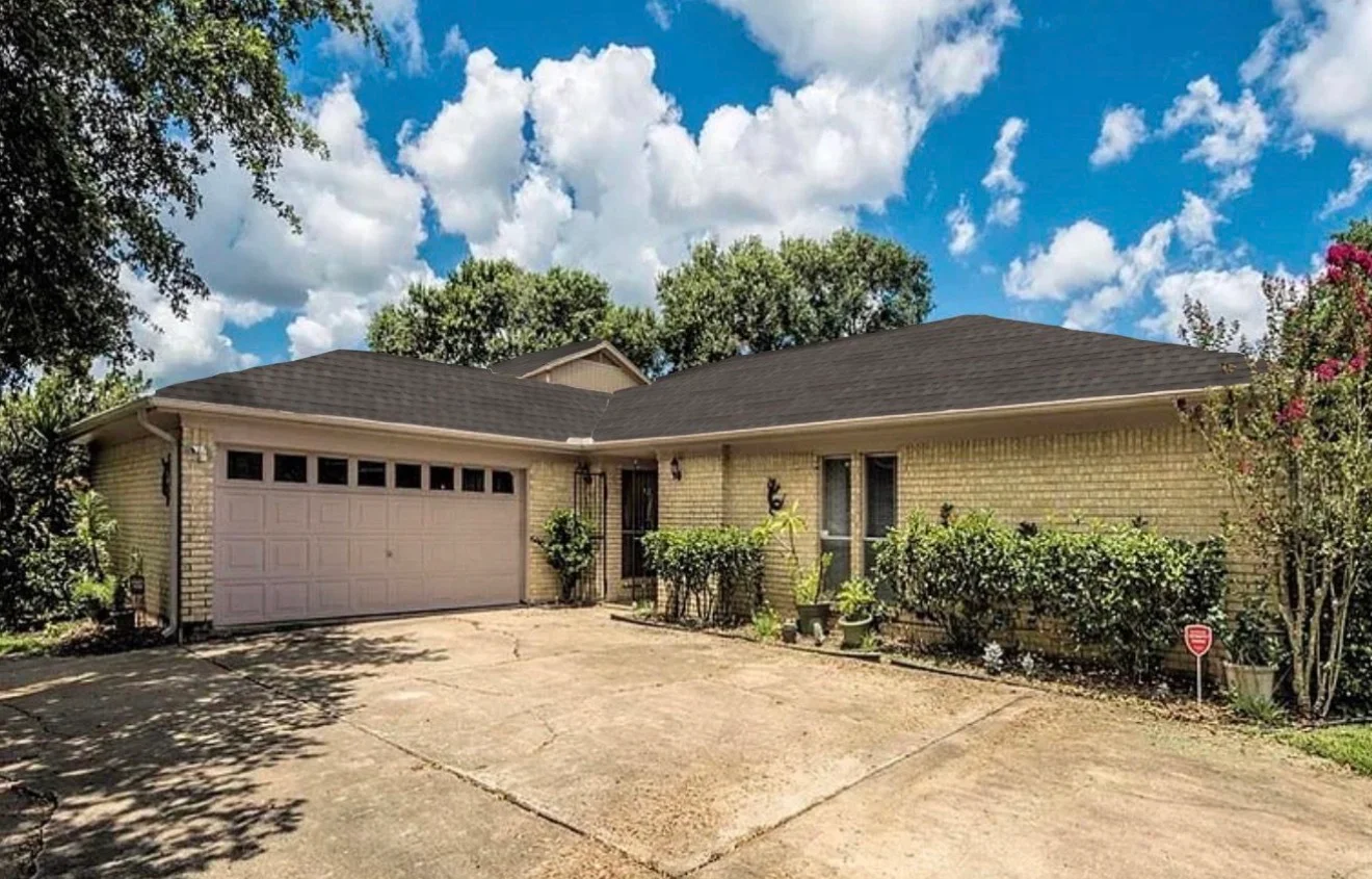 Dark asphalt shingle roof on brick single-story home with gable peak