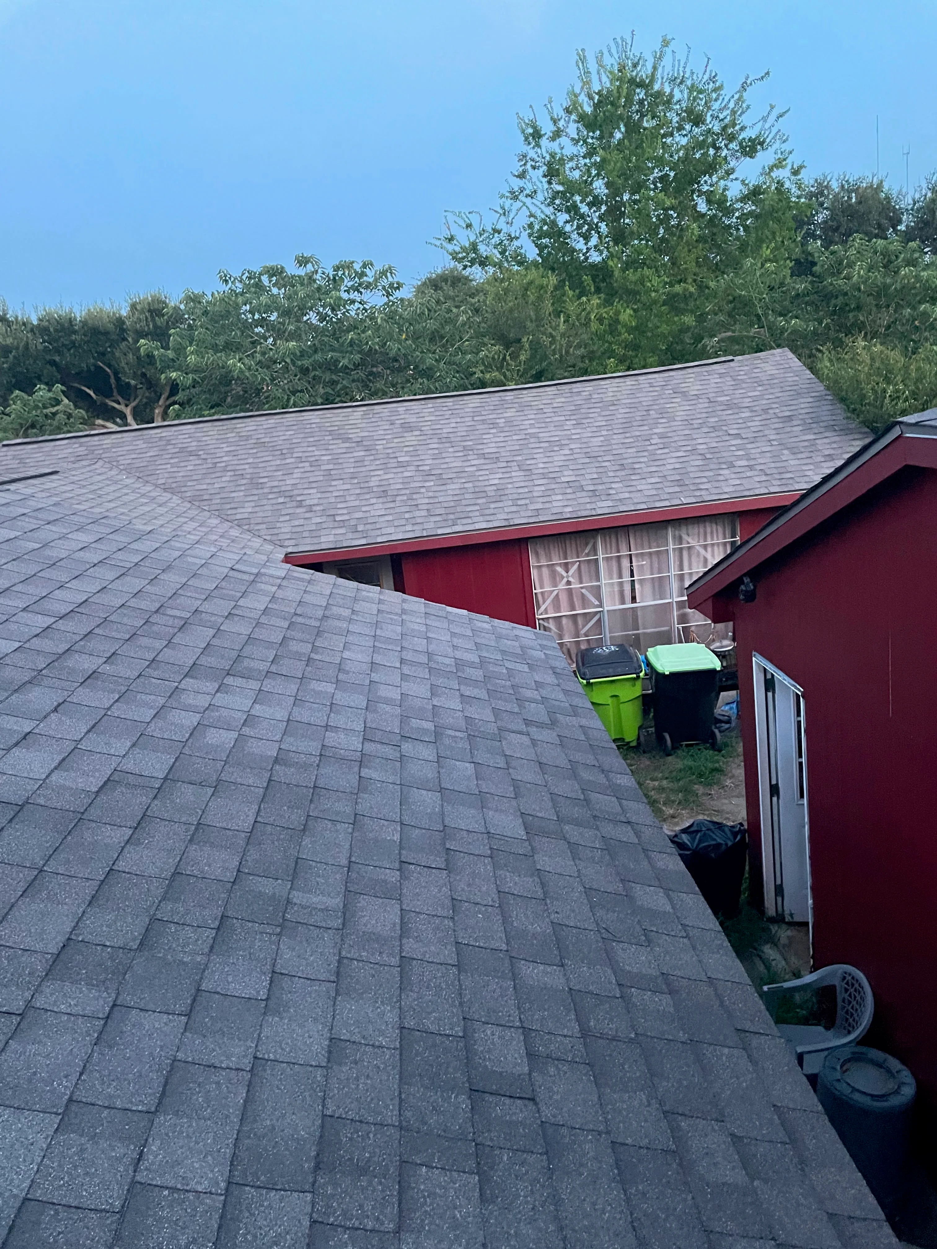 Gray dimensional asphalt shingle roof with red trim and proper flashing installation
