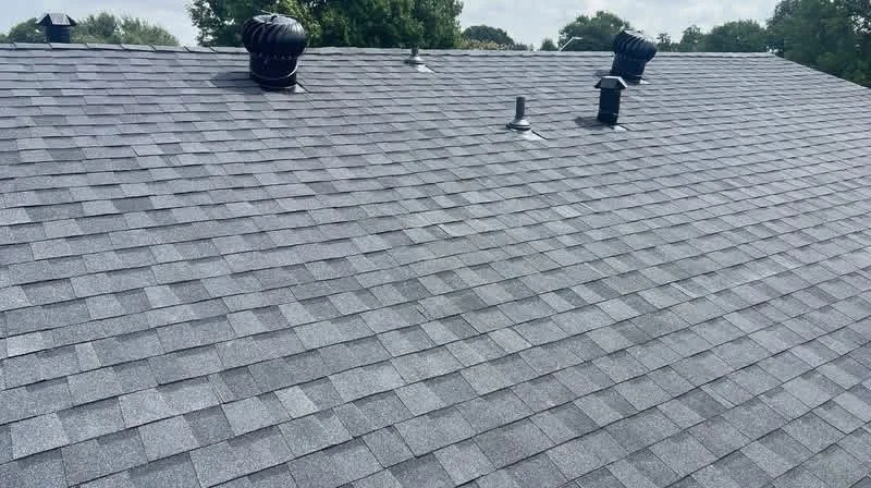 Gray architectural shingles installed on residential roof with roof vents and flashing