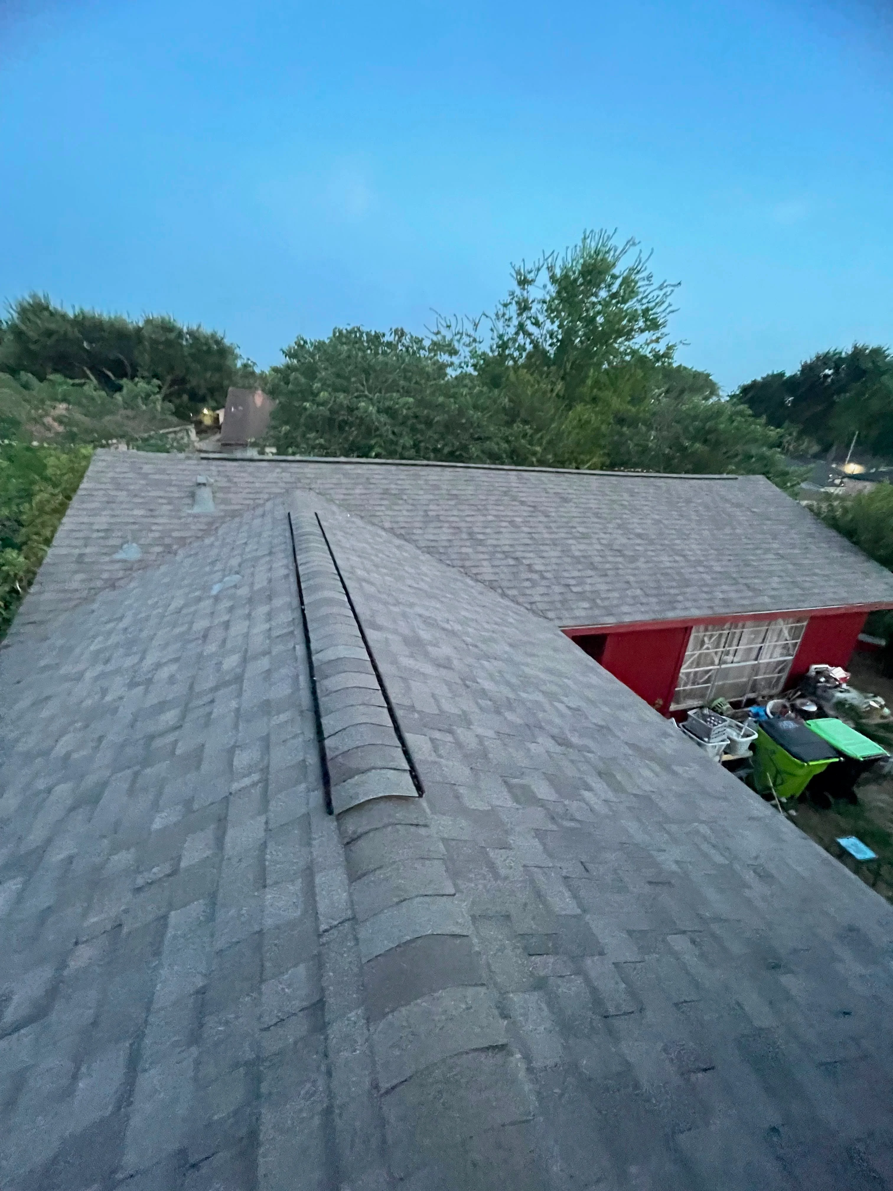 Gray asphalt shingle roof with ridge cap and proper installation on residential home