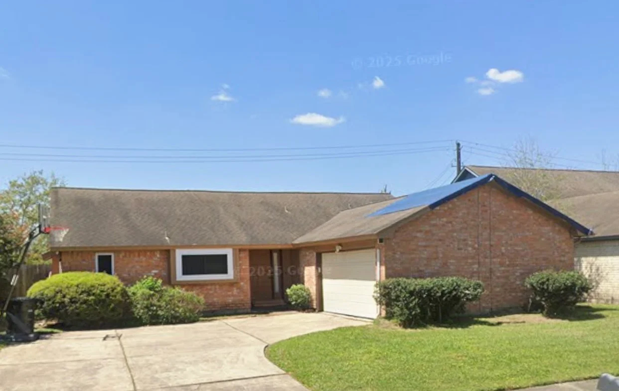 New gray and blue asphalt shingle roof on brick ranch home with white garage door