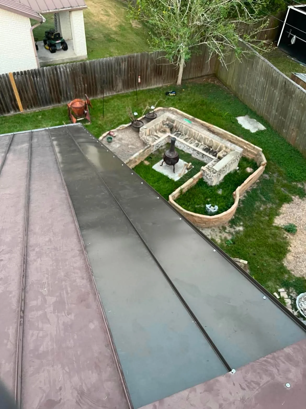 Standing seam metal roof with dark gray panels and visible seam lines