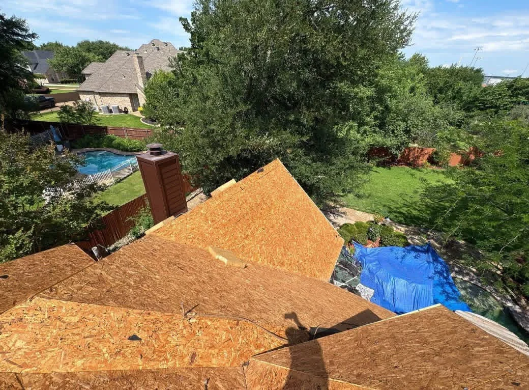 OSB roof sheathing installation with blue weather protection on residential home addition